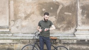 Man with a bike looking at his wristwatch